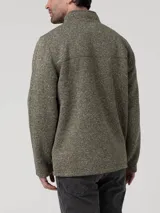 Polar de hombre color verde oliva jaspeado, con cuello alto y cierre frontal completo. Presenta un bolsillo vertical con cierre en el pecho y bolsillos laterales con cierre.