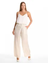 Pantalón de corte wide leg en tejido laminado metalizado color gris. Presenta pretina ancha elastizada con lazo de ajuste y bolsillos delanteros.