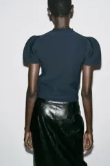 Jersey de punto liso color azul marino, con cuello redondo y mangas cortas abullonadas.