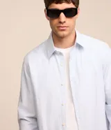 Camisa de vestir de hombre, corte regular, confeccionada en tejido de sastrería rayado. Tiene cuello solapa, abotonado delantero y mangas largas.