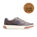 Zapato casual Hi-Tec Aron color marrón de cuero con detalle de una franja azul en el lateral, cordones verdes y suela blanca con base marrón.