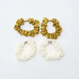 Pack de cuatro coleteros de tela satinada con detalle de aplique metálico dorado. El set incluye dos unidades en color verde oliva y dos unidades en color blanco.