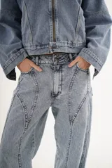 Pantalón de jean color marrón con costuras decorativas verticales en el frente, corte recto y tiro medio.