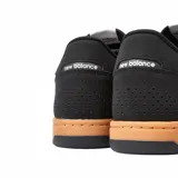 Championes New Balance modelo NM 440, color negro con logo blanco y suela marrón.