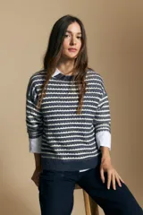 Sweater de punto con diseño de rayas horizontales en tonos tierra, con textura acanalada y cuello redondo. Presenta un corte relajado y mangas largas.