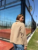 Campera color beige tejida en lana, de corte holgado y mangas largas.