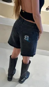 Bermuda de jean negro con ruedo desflecado y bordado con logo en el bolsillo trasero.