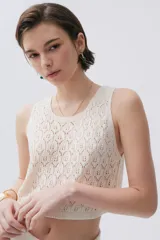 Top tejido color crudo con puntos calados, de calce corto y relajado.