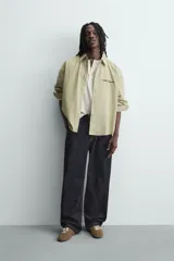 Camisa de corte boxy fit confeccionada en tejido de algodón con estampado de cuadros. Presenta cuello solapa, manga larga con puños abotonados, bolsillo plastrón en el pecho y cierre frontal de botones. Incluye un bordado a contraste en el pecho.