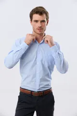 Camisa de vestir celeste rayada de manga larga, con cuello camisero, bolsillo ojal en el pecho y cierre frontal con botones.