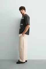 Camiseta de algodón con corte relajado, cuello redondo y manga corta. Presenta estampados gráficos a contraste en el frente con inscripciones tipo señalética.