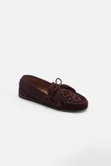 Mocasín de gamuza color bordó con detalle de flecos, cordones y tachas metálicas en la parte superior.