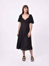 Vestido midi negro con escote en V, mangas cortas abullonadas y falda acampanada.
