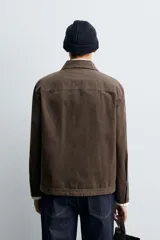 Sobrecamisa de corte regular fit confeccionada en tejido de algodón con acabado lavado. Presenta cuello solapa, cierre frontal de botones, mangas largas con puños abotonados y un bolsillo plastrón en el pecho.