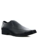 Zapato de vestir tipo mocasín o slip-on, color negro, con capellada de cuero liso y puntera cuadrada. Presenta un corte elástico lateral para facilitar el calce y un pequeño logo grabado en el lateral del talón.
