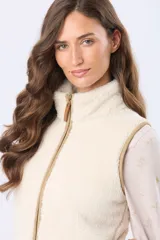 Chaleco de tejido sherpa color crema, con cierre frontal y detalles de terminación en eco cuero color tostado.