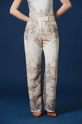 Pantalon de corte recto y amplio con estampado de paisaje natural en tonos beige, marrón y gris, tiro alto con cintura estructurada y trabillas.