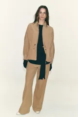 Pantalón blanco de tiro alto con pierna ancha y cordón ajustable en la cintura. Presenta bolsillos laterales y falsos bolsillos de vivo en la parte trasera.