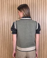 Chaleco tejido de punto 100% algodón, color crudo con detalles en tono tostado en el cuello redondo, sisas y dobladillo inferior.