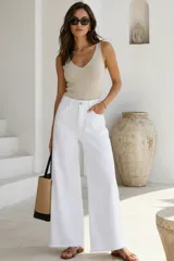 Jeans blancos de corte recto y tiro alto, confeccionados en denim con diseño de perneras amplias y terminación desflecada en el dobladillo.