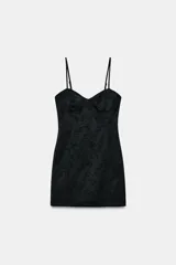 Vestido corto de estilo lencero con escote en pico y copas estructuradas. Presenta tirantes finos ajustables y un diseño de tejido jacquard con estampado floral tono sobre tono.