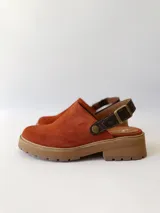 Zueco de cuero color ladrillo con correa trasera ajustable color marrón oscuro y suela track color marrón claro.