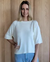 Buzo de punto color crema, con mangas cortas y cuello redondo. Tejido con detalle de punto acanalado en cuello, puños y ruedo.