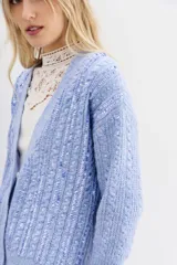 Cardigan de punto gris, corte relajado y mangas largas, con frente completamente cubierto de lentejuelas.