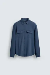 Camisa de corte relajado confeccionada en tejido con mezcla de viscosa. Presenta cuello solapa, manga larga con puños abotonados, bolsillos de plastrón con solapa en el pecho y cierre frontal de botones.