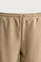 Bermuda estilo jogger de ajuste relajado, color beige, con cintura elástica ajustable mediante cordón y bolsillos delanteros.