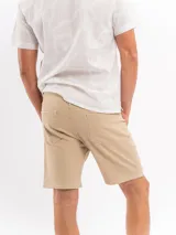 Bermuda beige de corte clásico, confeccionada en mezcla de algodón y elastano, con bolsillos laterales y traseros.