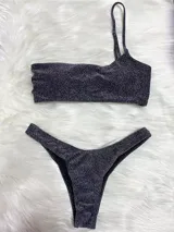 Conjunto de bikini de dos piezas color plateado brillante, con corpiño de un solo hombro y bombacha cavada.