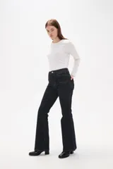 Pantalon de jean azul oscuro con corte flare, tiro alto y bolsillos frontales tipo parche.
