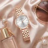 Reloj analógico de mujer con caja redonda y malla de eslabones metálicos en tono oro rosa. Presenta una esfera minimalista con índices brillantes y movimiento de cuarzo japonés.