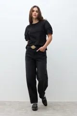 Remera negra de algodón con cuello redondo y mangas cortas abullonadas con detalle de frunces.