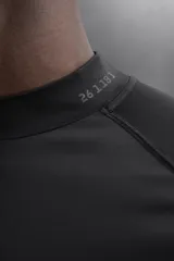 Camiseta negra de running de primera capa, confeccionada en tejido elástico y ajustado al cuerpo. Tiene cuello alto con logo estampado, mangas largas con puños ajustables y costuras planas.