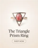 Anillo de plata 925 con diseño triangular y piedra central ovalada de raíz de rubí en tonos rosados.