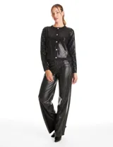 Cardigan de punto con frente bordado en lentejuelas negras. Presenta mangas largas y espalda en tejido rib, con cierre frontal de botones metálicos decorados.