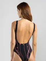 Malla entera negra con estampado de cadenas y flores rosadas. Incluye cinturón fino con hebilla dorada.