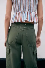 Pantalón cargo de tiro medio con pinzas delanteras, bolsillos laterales de plastrón y cierre frontal con cremallera y botón. Presenta una pernera holgada que se estrecha ligeramente hacia el bajo.
