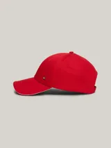 Gorra de béisbol roja de seis paneles, con visera curva, ojales de ventilación y pequeña placa metálica con el logo de la marca en el lateral frontal.