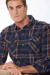 Sobrecamisa de estilo leñador con estampado de cuadros, confeccionada en tela de viyela. Presenta cuello clásico, cierre frontal con botones y dos bolsillos con solapa en el pecho.