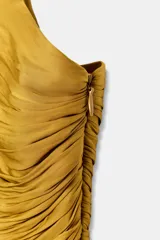 Mono largo de escote en pico con tirantes finos, cuerpo con tejido drapeado y pernera ancha. Cuenta con cierre lateral con cremallera oculta.