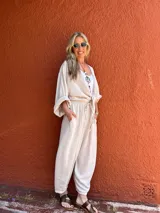 Pantalón de corte amplio color beige, con cintura elástica y lazo ajustable.
