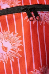 Cooler pequeña con estampado de rayas verticales rojas y flores rosas. Cuenta con manija jacquard en blanco y negro con el monograma Polonio, cierre invisible y interior sellado. Fabricada en poliéster reciclado y aislada con espuma PE laminada en aluminio.