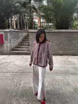 Cardigan de tejido de punto a rayas horizontales, color bordó y blanco crudo, con botones frontales y cuello redondo.