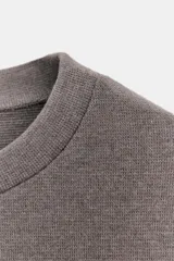 Top de cuello redondo y manga corta, confeccionado en tejido suave con costura central vertical y cintura entallada.