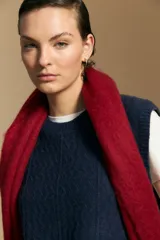 Chaleco tejido de punto en color azul marino, con diseño de textura sutil en relieve, escote redondo y terminaciones acanaladas en cuello, sisas y ruedo.