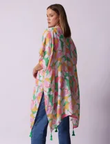 Kimono tejido con estampado floral multicolor y terminación de ruedo con borlas verdes.