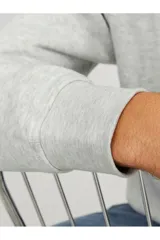 Buzo de cuello redondo y manga larga, confeccionado en tejido de bucle color gris melange. Presenta un corte relajado y un pequeño estampado tipográfico en el centro del pecho.